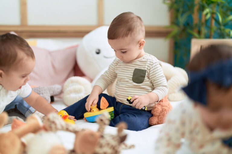 Group of toddlers sitting on bed playing with toys at kindergarten